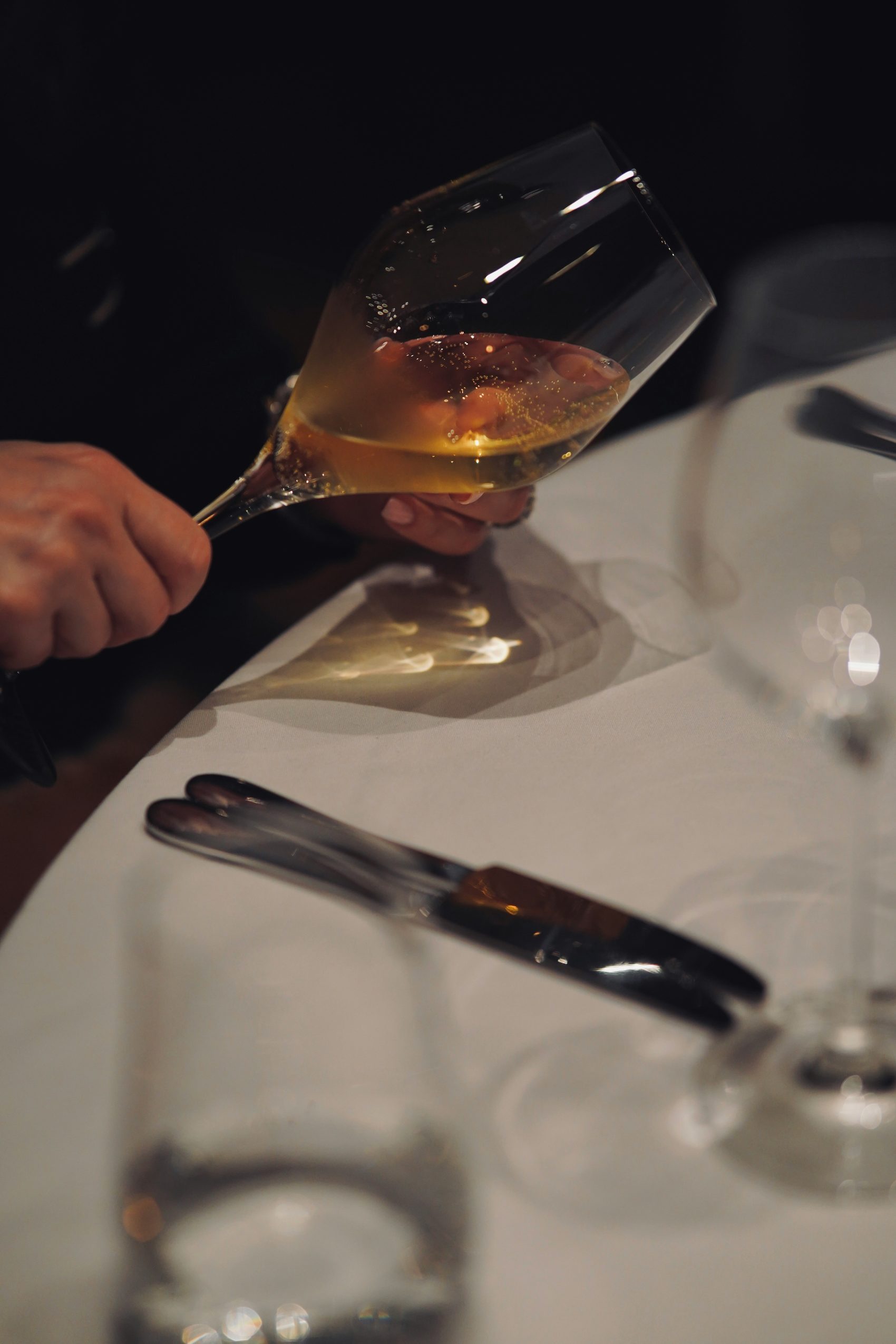 A glass of wine considered over the dinner table