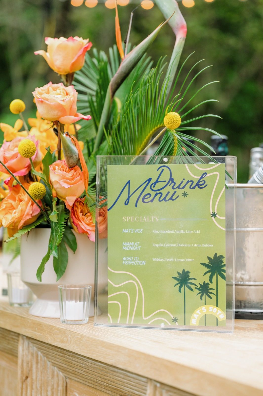 The drink menu propped at the garden bar beside peach roses