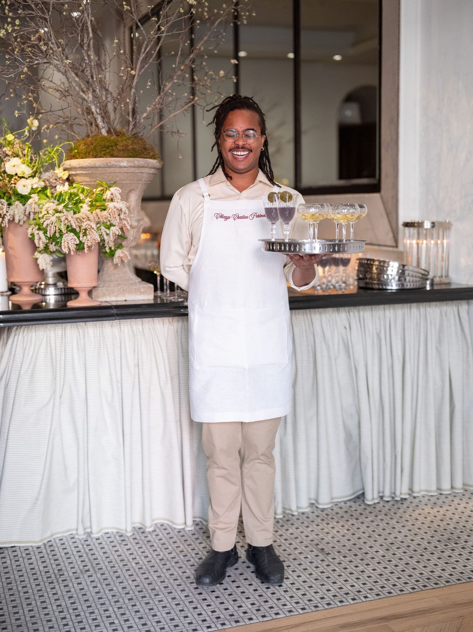 A Vendador server smiles with a tray of welcome drinks