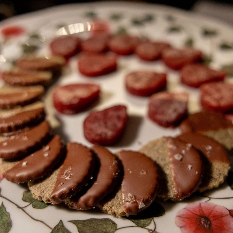 Buckwheat cocoa nib sablés and strawberry Tasmanian pepperberry pâte de fruit on floral china