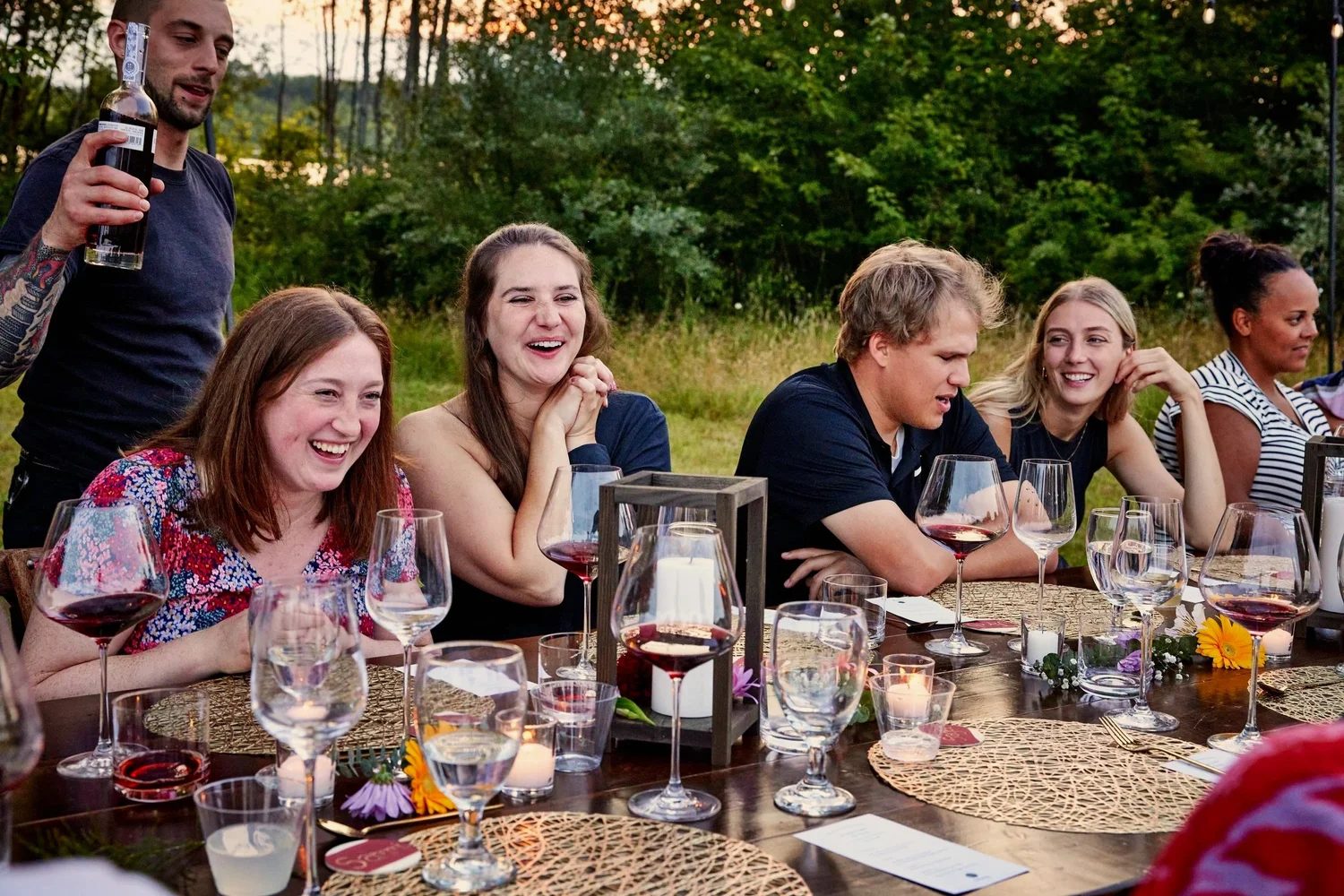 Guests gathered around a long getaway table at golden hour