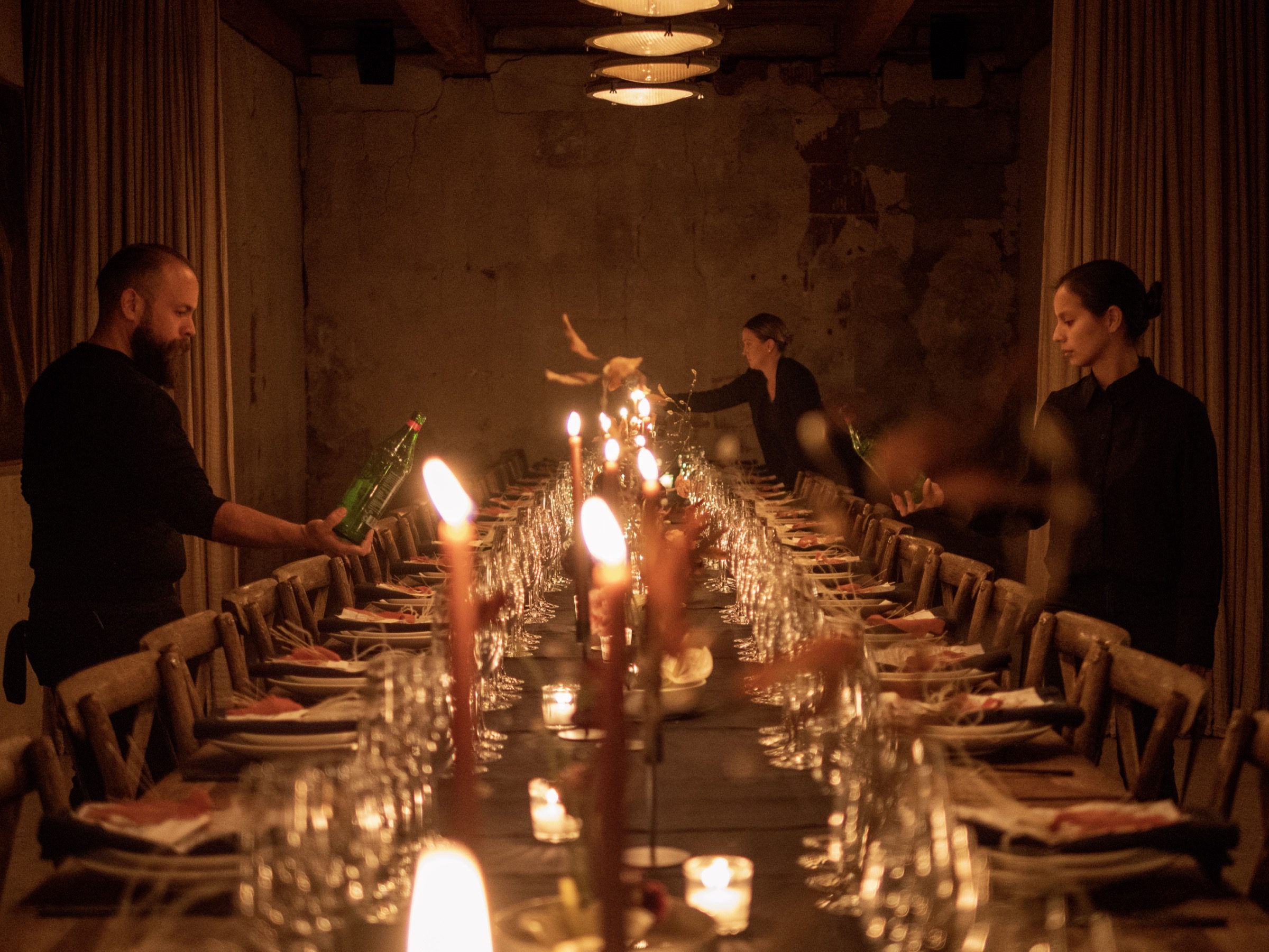 The Vendador team dressing a long candlelit table before service